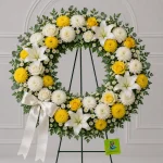 A large circular sympathy wreath featuring 4 white lilies